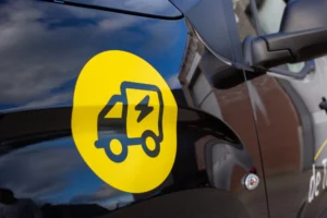 Close-up van een elektrische bestelwagen van De Transporters met geel pictogram van een vrachtwagentje met bliksemschicht op de zijkant.
