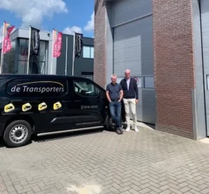 Max Ziemerink en Peter Kuyper bij een De Transporters-bus. 